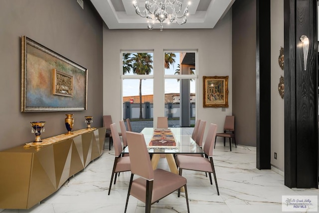 dining space with a tray ceiling and a notable chandelier