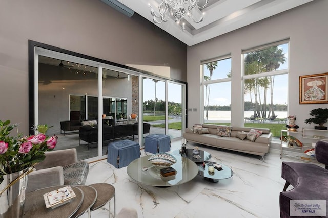 sunroom with a water view and a notable chandelier