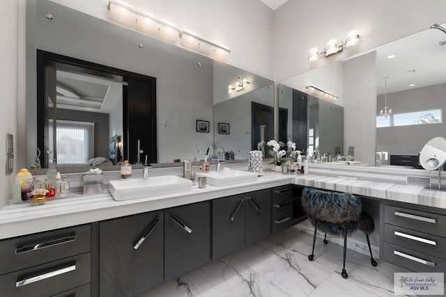 bathroom featuring a chandelier, vanity, and plenty of natural light