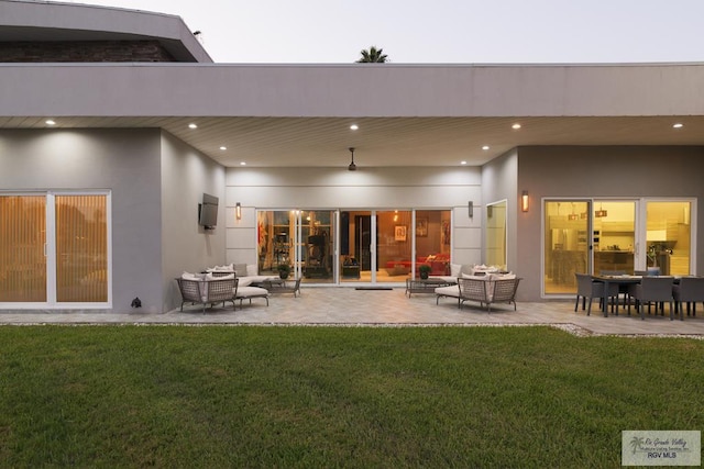 back of house featuring a lawn, a patio area, and an outdoor hangout area