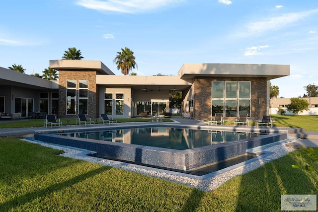 view of swimming pool with a lawn, a patio area, and ceiling fan