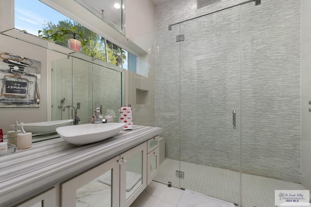 bathroom featuring tile patterned floors, vanity, a healthy amount of sunlight, and an enclosed shower