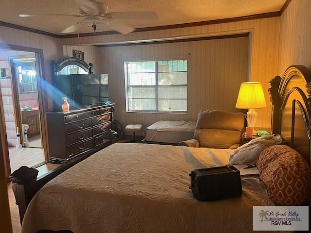 bedroom with ceiling fan, ornamental molding, and a textured ceiling