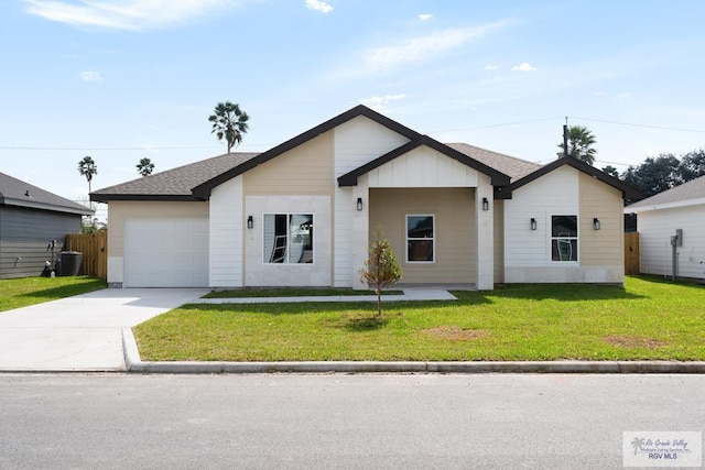 view of front of property featuring a garage, a front yard, and cooling unit