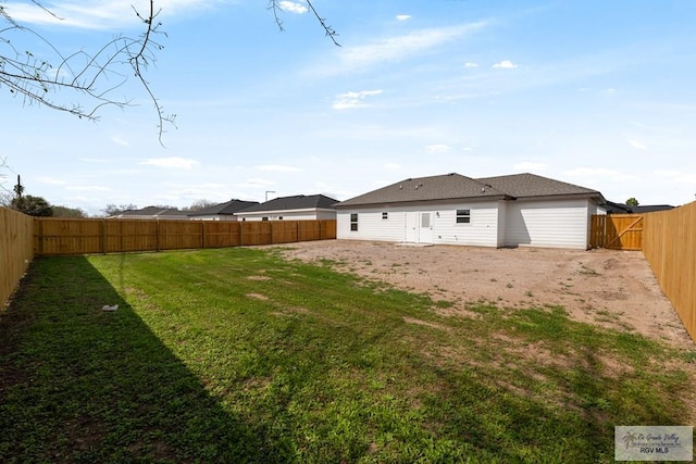 rear view of house featuring a yard