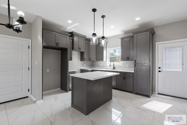 kitchen with pendant lighting, sink, gray cabinetry, an inviting chandelier, and a center island