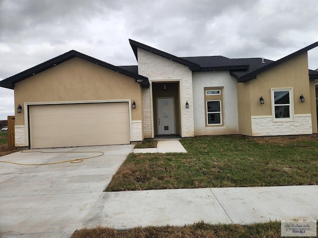 view of front of property featuring a front yard and a garage