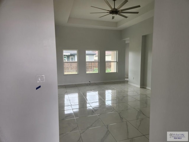 spare room featuring a tray ceiling, a towering ceiling, and ceiling fan