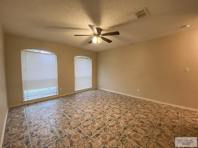 spare room featuring ceiling fan and a textured ceiling