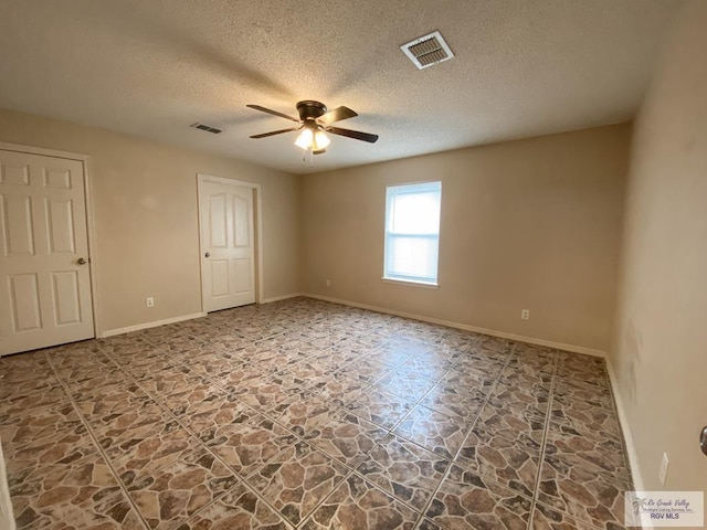 spare room with a textured ceiling and ceiling fan