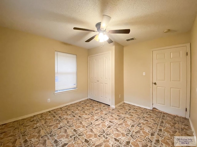 unfurnished bedroom with ceiling fan, a closet, and a textured ceiling