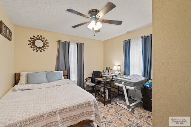 bedroom featuring ceiling fan and a textured ceiling