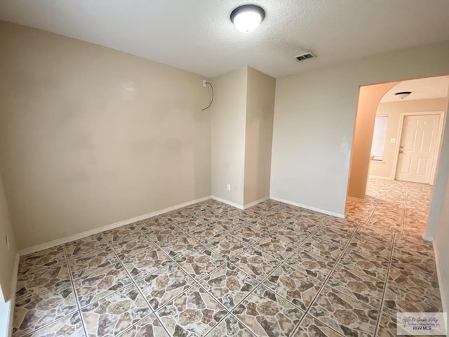 unfurnished room featuring a textured ceiling