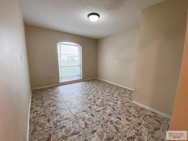 unfurnished room with a textured ceiling