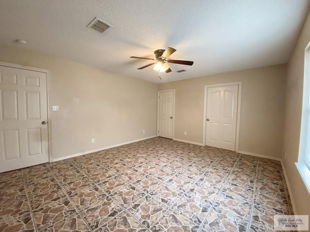 empty room with ceiling fan and a textured ceiling