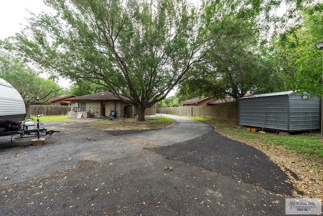 exterior space with an outdoor structure, a storage unit, and fence
