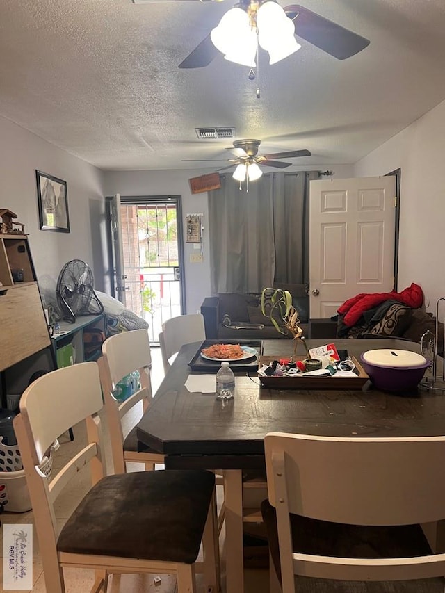 dining room with visible vents, ceiling fan, and a textured ceiling