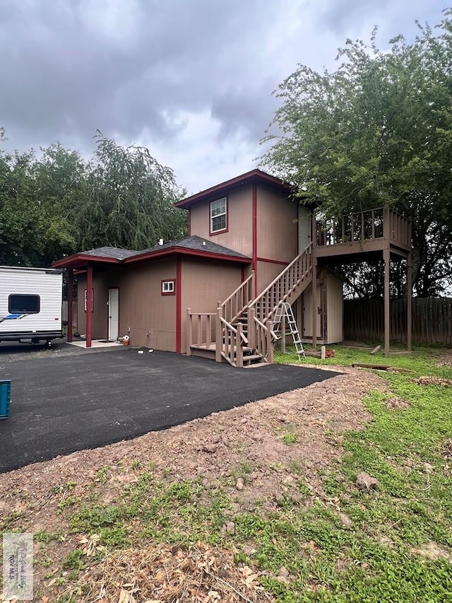 exterior space featuring a deck, stairway, and fence