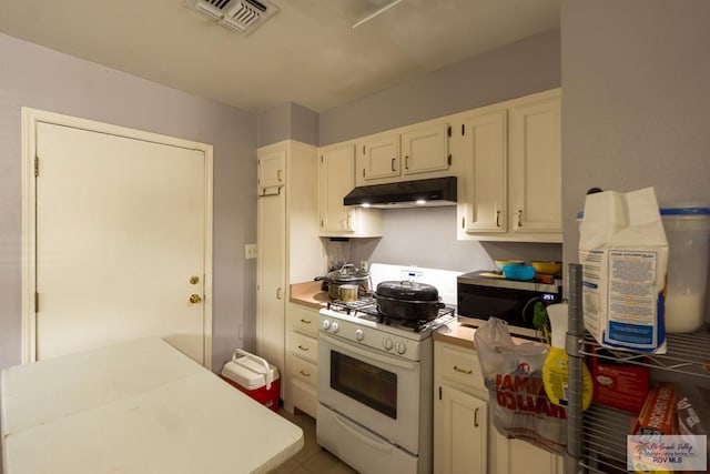 kitchen featuring stainless steel microwave, under cabinet range hood, white range with gas cooktop, visible vents, and light countertops