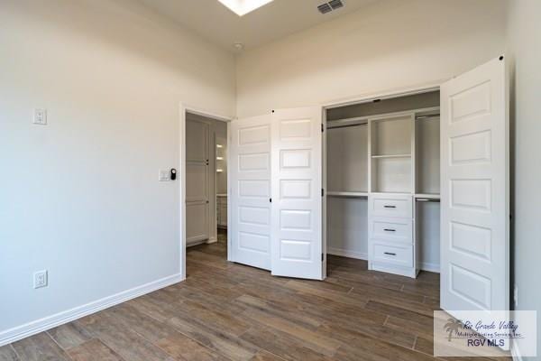 unfurnished bedroom featuring dark wood-type flooring and a closet