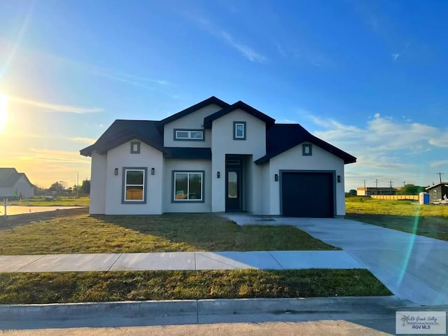 view of front of house with a garage and a yard