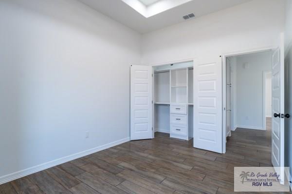 unfurnished bedroom featuring a closet and dark hardwood / wood-style floors