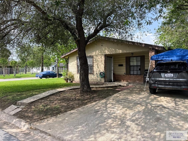 view of front facade with fence, brick siding, and a front yard