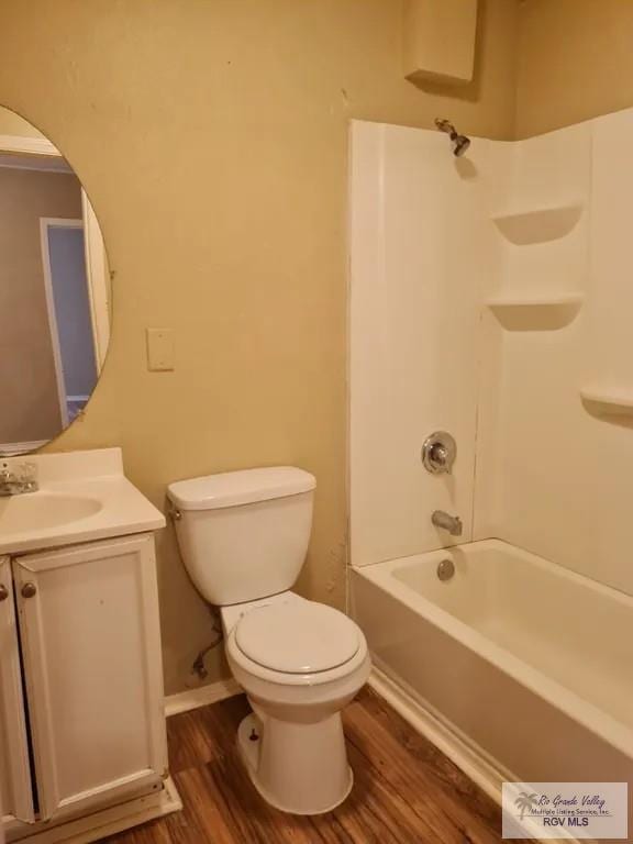 bathroom featuring wood finished floors, toilet, vanity, and bathing tub / shower combination
