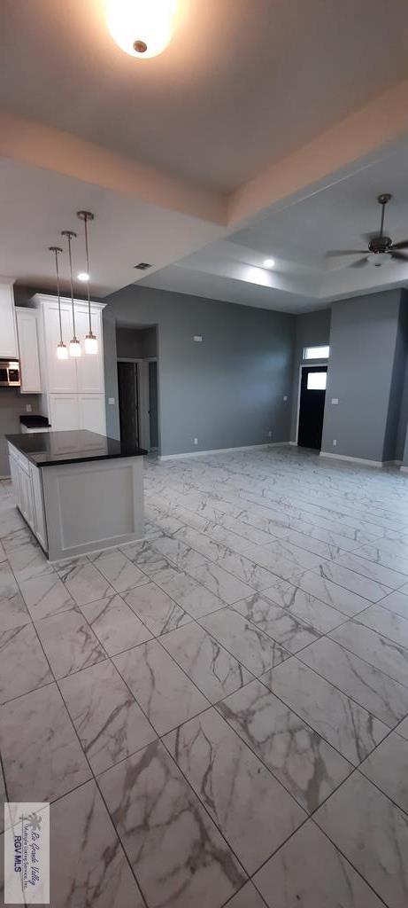 unfurnished living room featuring ceiling fan