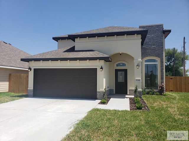 5200 Umar Ave, Mission, TX 78573 - view of front of house featuring a front yard, a garage, fence, concrete driveway, and stone siding