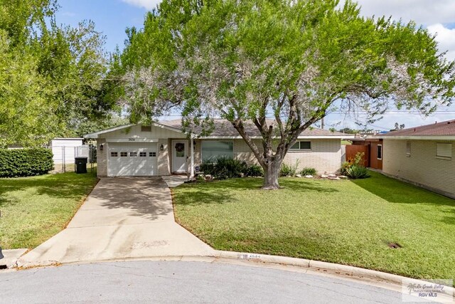 single story home with a garage and a front lawn