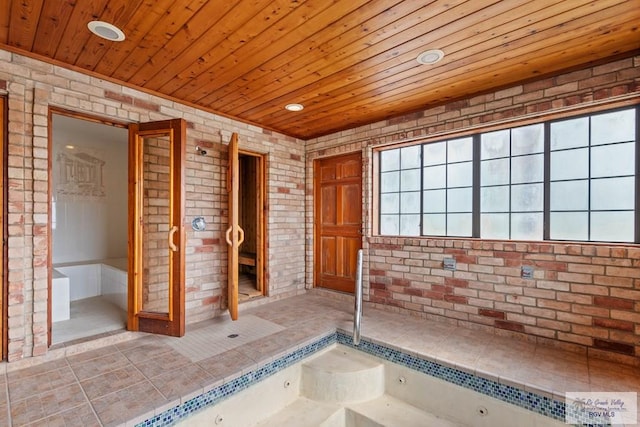 bathroom featuring brick wall and wooden ceiling