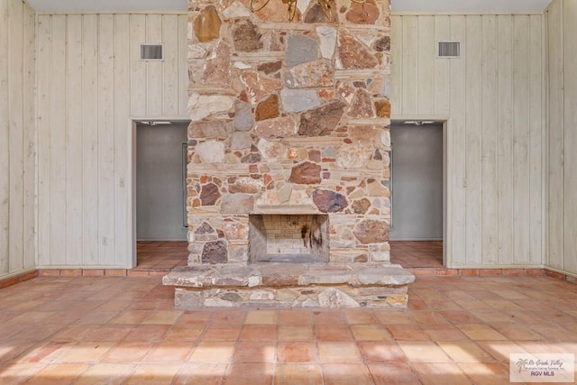 room details featuring baseboards, wood walls, and visible vents