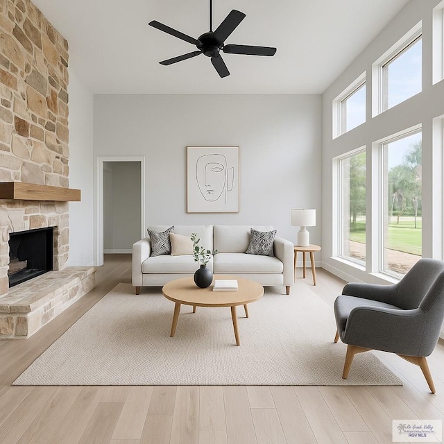 living room featuring ceiling fan, wood finished floors, and a fireplace