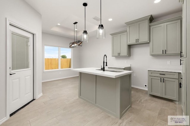 324 N Leon Ave, Elsa, TX 78543 - kitchen featuring gray cabinetry, a sink, an island with sink, recessed lighting, and baseboards