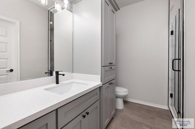 324 N Leon Ave, Elsa, TX 78543 - full bath with a stall shower, toilet, vanity, and baseboards