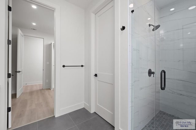 bathroom with hardwood / wood-style flooring and walk in shower