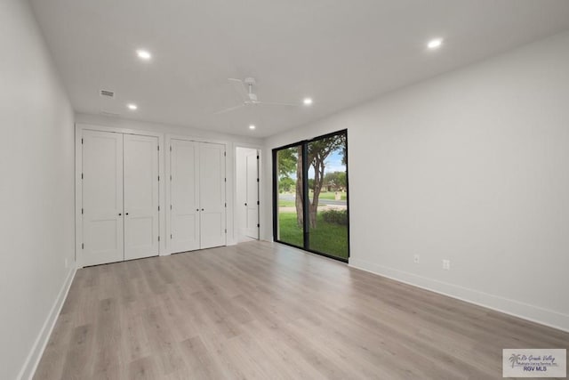 unfurnished bedroom featuring ceiling fan, access to exterior, multiple closets, and light hardwood / wood-style flooring