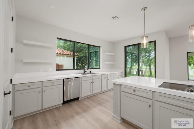 kitchen featuring dishwasher, white cabinetry, plenty of natural light, and decorative light fixtures