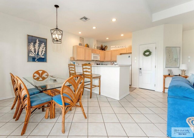 dining space featuring light tile patterned floors and a chandelier