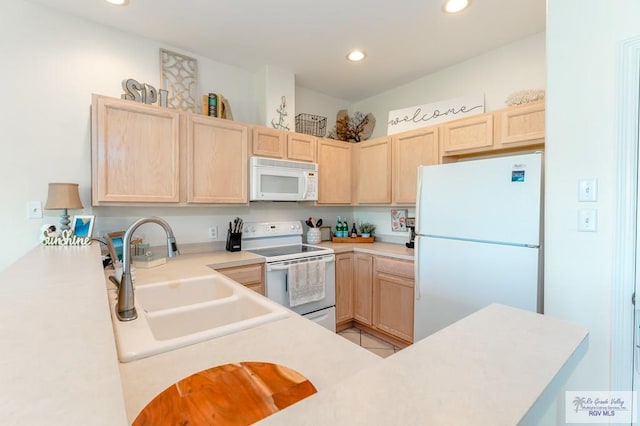 kitchen featuring kitchen peninsula, light brown cabinets, white appliances, and sink