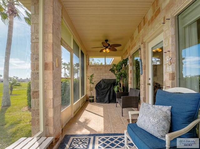 sunroom / solarium featuring ceiling fan and wood ceiling