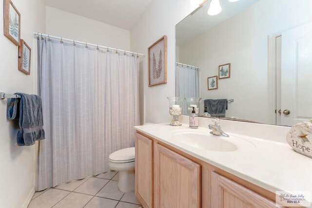 bathroom with tile patterned floors, vanity, toilet, and walk in shower