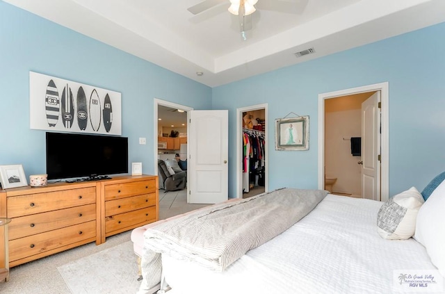 bedroom featuring ensuite bathroom, ceiling fan, a walk in closet, and a closet