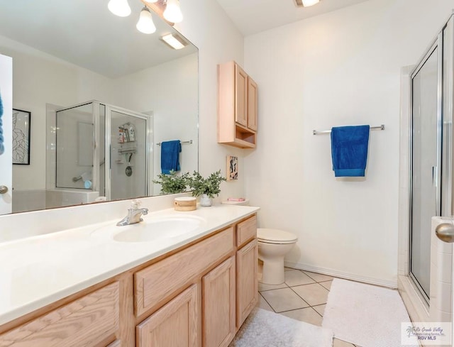 bathroom with tile patterned floors, a shower with door, vanity, and toilet