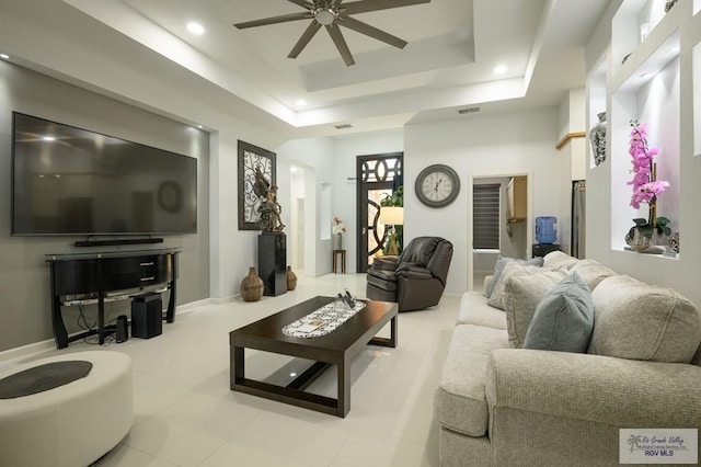 living room featuring a tray ceiling and ceiling fan