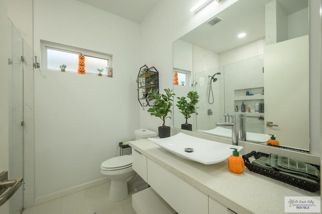 bathroom with tile patterned flooring, vanity, toilet, and a shower with door