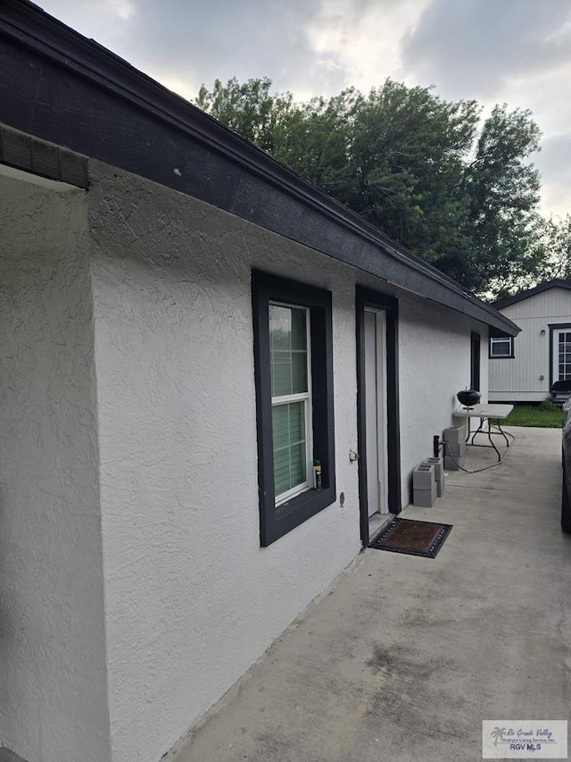 384 Colorado Dr, San Benito, TX 78586 - view of home's exterior with stucco siding and a patio area