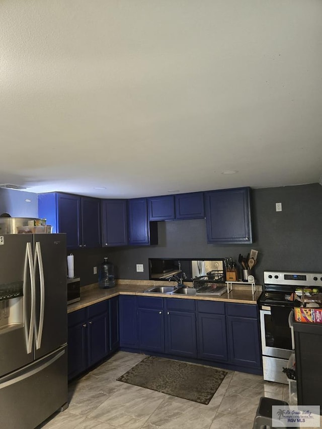 384 Colorado Dr, San Benito, TX 78586 - kitchen featuring appliances with stainless steel finishes, blue cabinetry, a sink, and light countertops