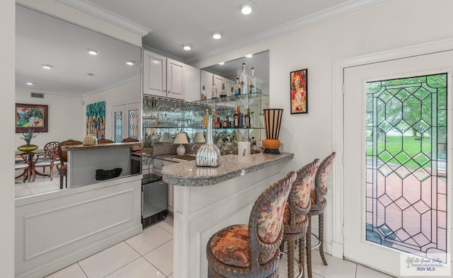 2301 Riverside Dr, Harlingen, TX 78550 - bar with light tile patterned floors, ornamental molding, visible vents, and a dry bar
